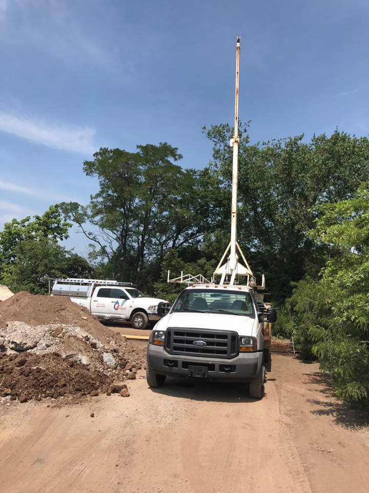 Two Paramount Well Service trucks on-site for commercial irrigation installation.