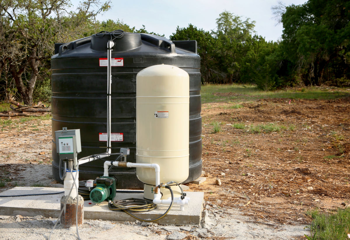 A water well pressure tank installed on a concrete slab.